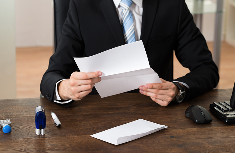 Man in suit reading business letter